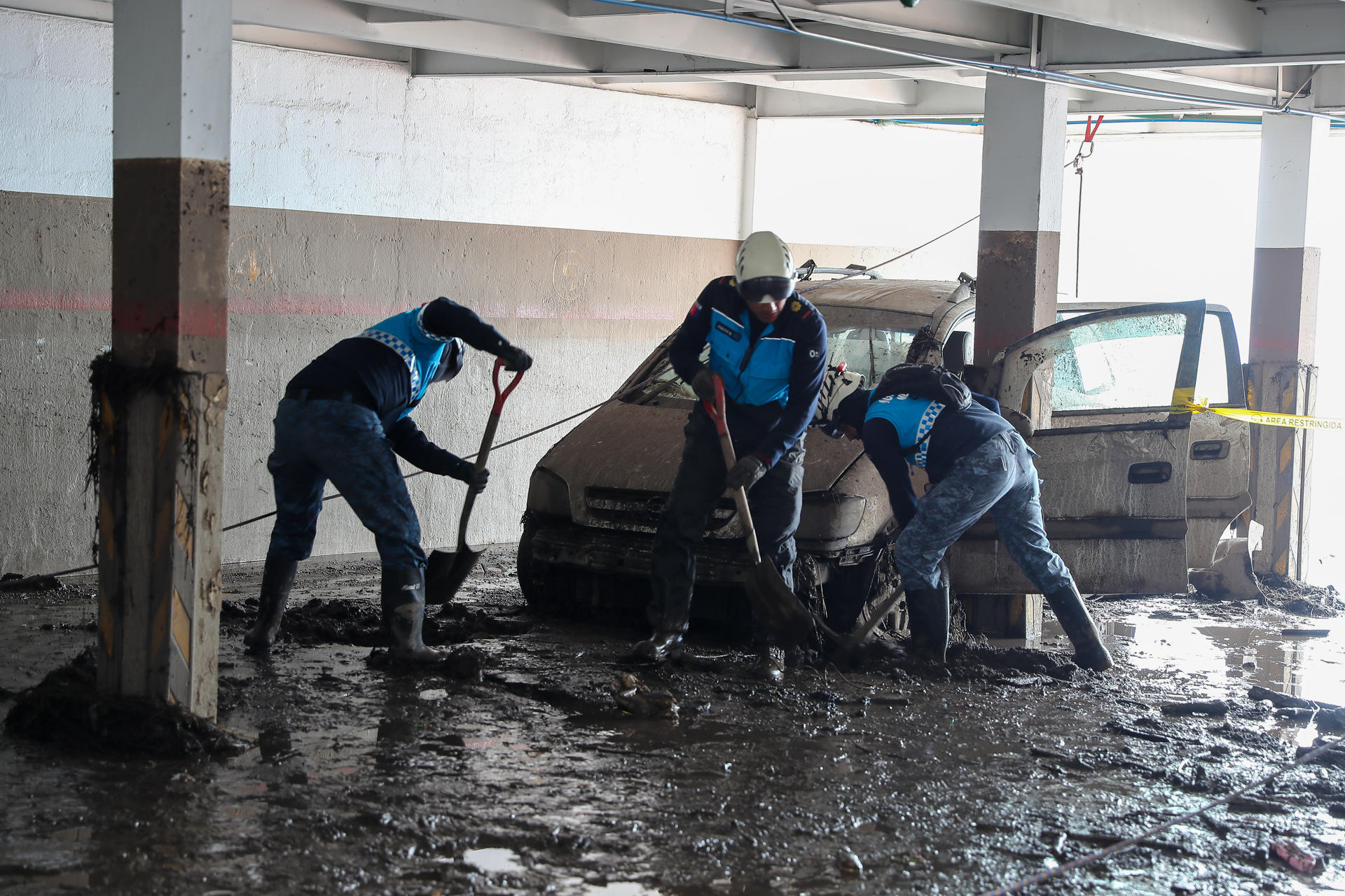 Obreros ecuatorianos ayudan este miércoles con la limpieza tras el aluvión ocurrido el martes, en el barrio La Gasca, en Quito (Ecuador). EFE/ José Jácome