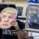 Fotografía de archivo donde se aprecia dos personas con un retrato de Biden y una máscara de Trump. EFE/EPA/CRISTOBAL HERRERA-ULASHKEVICH
