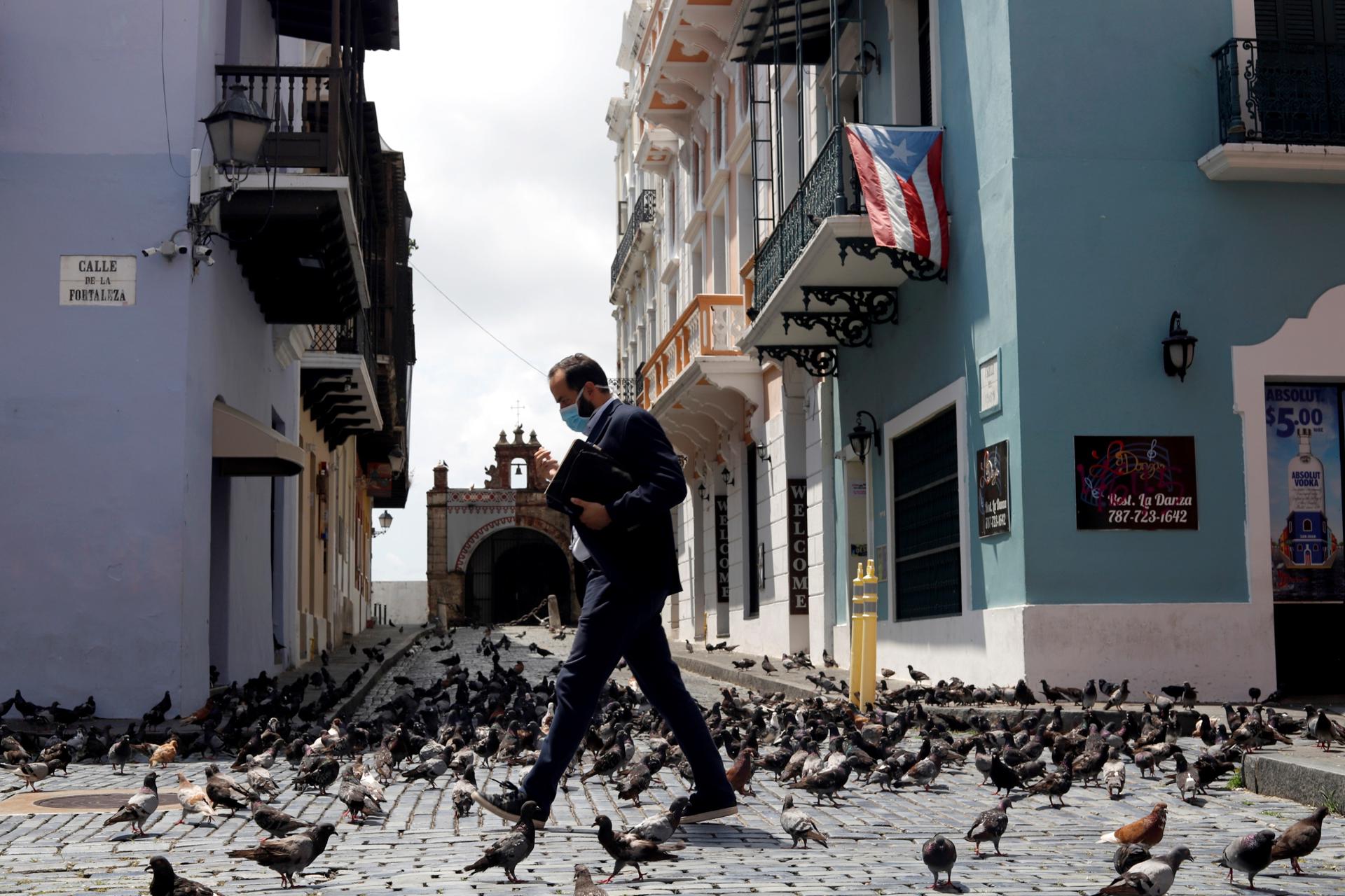Un hombre camina en la calle Fortaleza junto a la sede del Ejecutivo en San Juan (Puerto Rico). Archivo. EFE/Thais Llorca