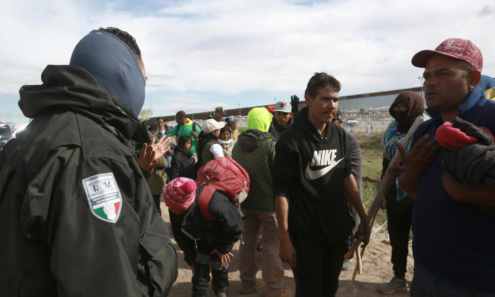 Personal del Instituto Nacional de Migración (INM) y un grupo de migrantes dialogan tras una trifulca este martes, en las inmediaciones de la frontera con Estados Unidos, en Ciudad Juárez (México). EFE/Luis Torres