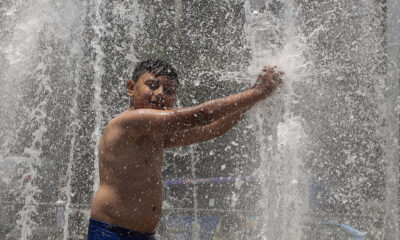 Un niño se baña en una fuente pública, debido a las altas temperaturas registradas en la Ciudad de México (México). EFE/José Méndez