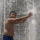 Un niño se baña en una fuente pública, debido a las altas temperaturas registradas en la Ciudad de México (México). EFE/José Méndez