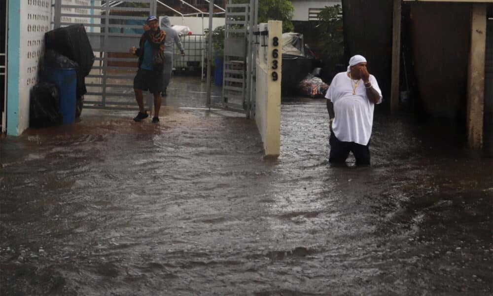 Personas caminan en una calle inundada debido a lluvias en Toa Baja (Puerto Rico). Imagen de archivo. EFE/Thais LLorca