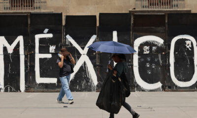 Varias personas caminan con sombrilla para protegerse del sol en Ciudad de México (México). EFE/José Méndez
