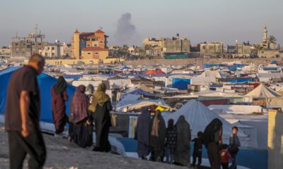Desplazados internos palestinos permanecen en un campamento mientras se eleva humo al fondo tras un ataque aéreo israelí, en Rafah, sur de la Franja de Gaza, 07 de mayo de 2024 (publicado el 08 de mayo de 2024). El 6 de mayo, las Fuerzas de Defensa de Israel (FDI) pidieron a los residentes del este de Rafah que evacuaran "temporalmente" a una zona humanitaria ampliada. EFE/MOHAMMED SABER