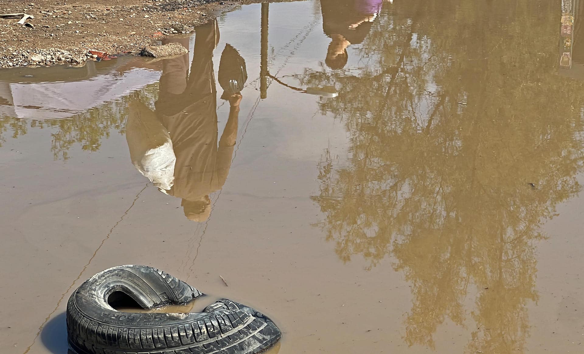 Personas caminan entre agua estancada en una calle, este viernes en Oaxaca (México). EFE/ Jesús Méndez