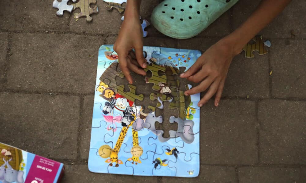 Fotografía de archivo del 25 de agosto de 2023 de una niña mientras juega con un rompecabezas en el parque Monumento a la Madre en la ciudad de Danlí, al oriente de Honduras. EFE/Gustavo Amador