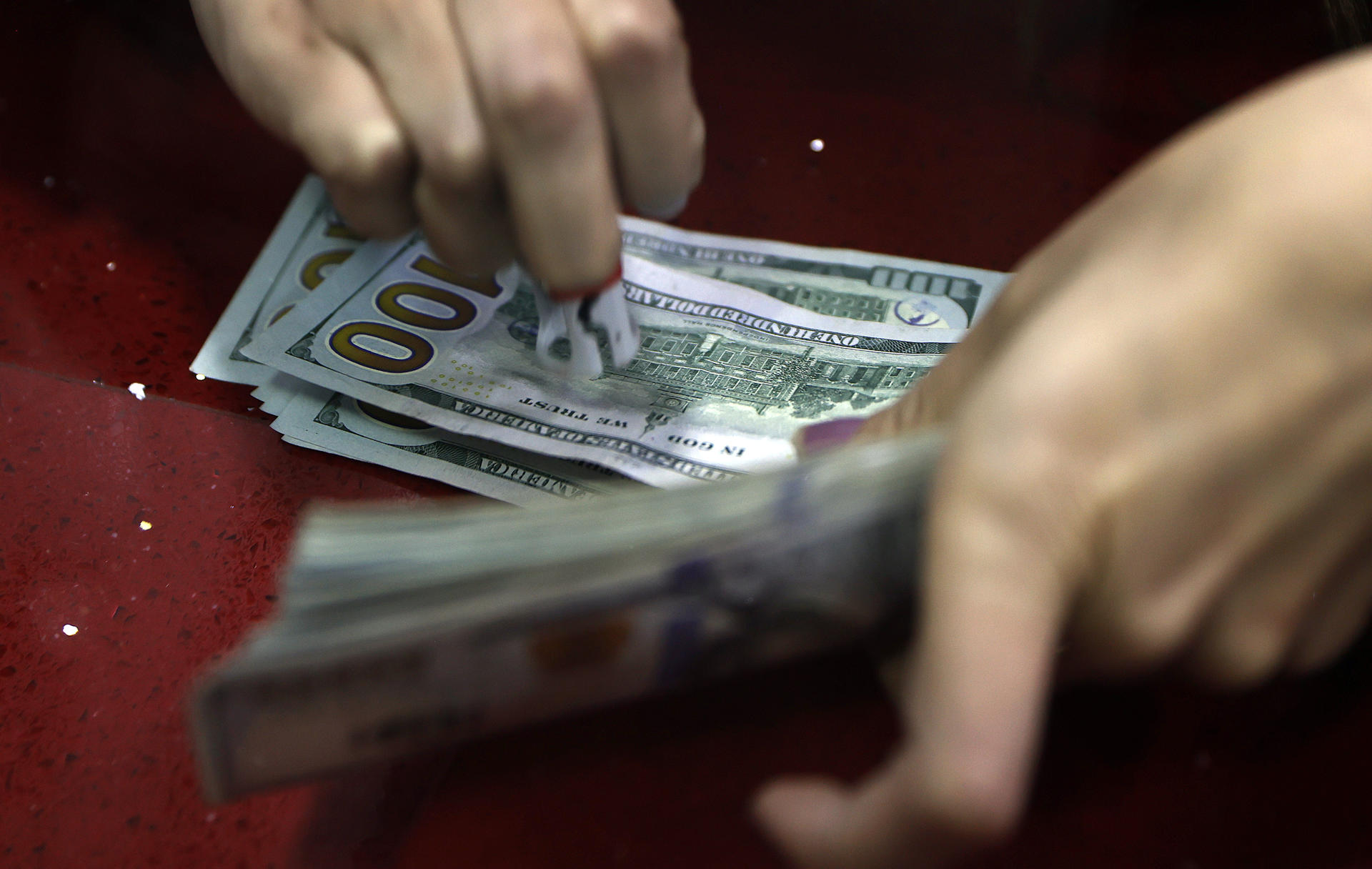 Fotografía de archivo que muestra a una mujer mientras cuenta billetes de dólar en una casa de cambio. Imagen de archivo. EFE/ Mauricio Dueñas Castañeda