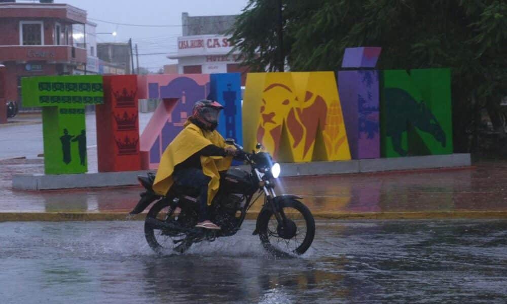 Un hombre protegido con capa maneja su moto en medio de un fuerte aguacero en la población de Tizimin en el estado de Yucatán (México). Imagen de archivo. EFE/ Cuauhtemoc Moreno