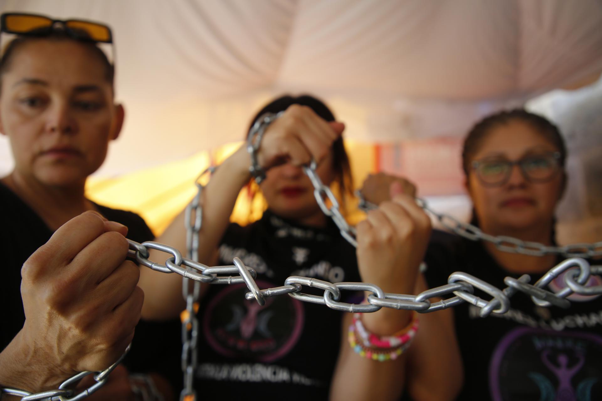 Un grupo de mujeres se encadenan durante una protesta este miércoles, para exigir la aprobación de la Ley contra la Violencia Vicaria en la ciudad de Guadalajara (México). EFE/Francisco Guasco