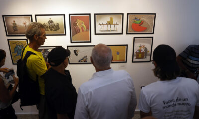 Visitantes observan una exposición de caricaturas durante la primera Bienal de Humor Político, este viernes en La Habana (Cuba). EFE/ Ernesto Mastrascusa