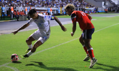 Andy Najar (i) de Honduras disputa el balón con Karel Pérez de Cuba este jueves, en un partido de las eliminatorias de Concacaf para el Mundial 2026. EFE/ Gustavo Amador