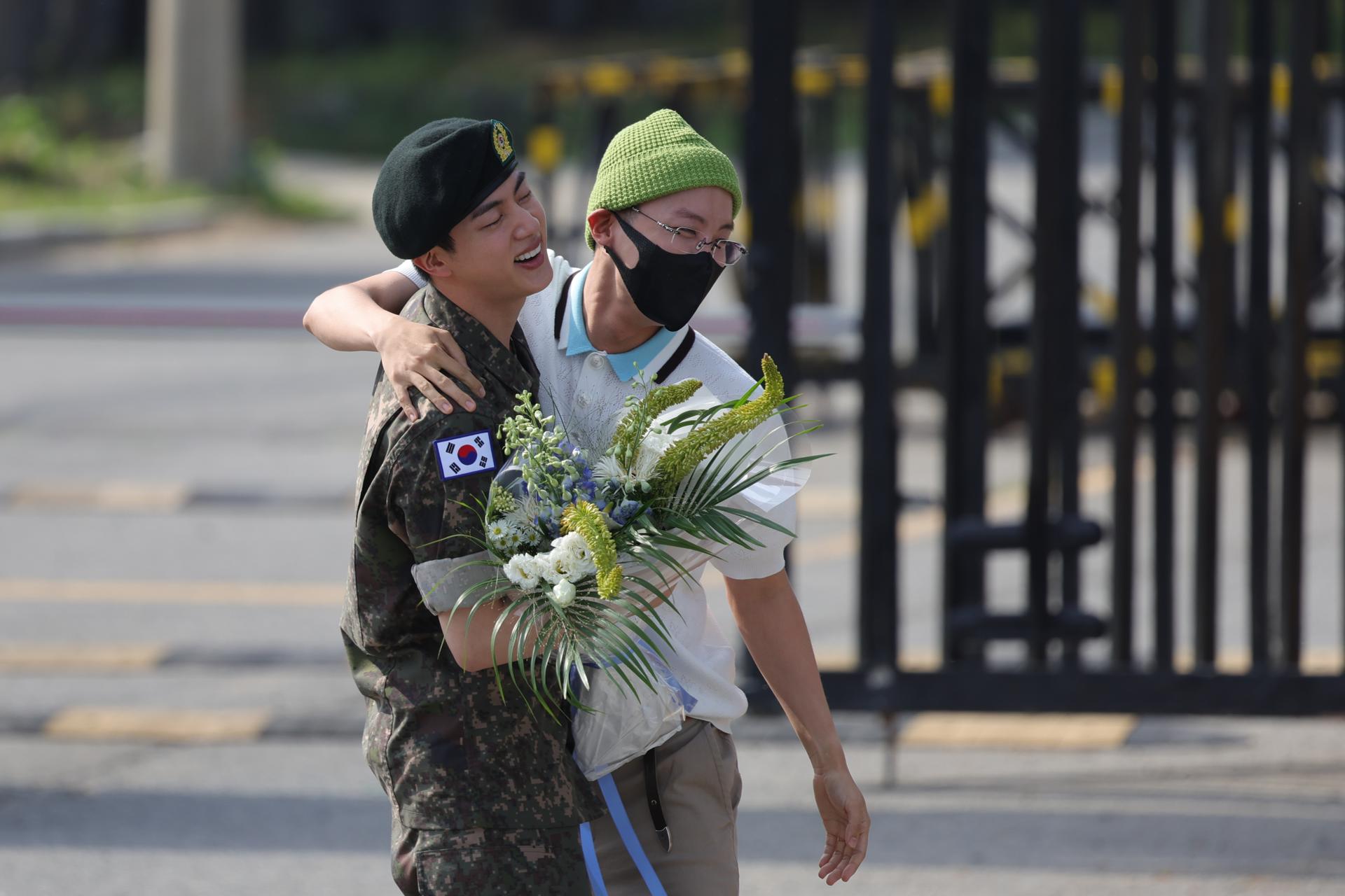 Jin (izq.), miembro de BTS, es recibido por su compañero de banda J-Hope frente a la puerta principal de la 5.a División de Infantería del Ejército después de completar sus 18 meses de servicio militar obligatorio. EFE/EPA/YONHAP SOUTH KOREA OUT