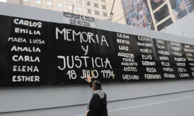 Fotografía de archivo de un hombre tocando un cartel con nombres de víctimas durante un acto conmemorativo por los 25 años del atentado contra la mutua judía AMIA, en Buenos Aires (Argentina). EFE/ Enrique G. Medina