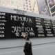 Fotografía de archivo de un hombre tocando un cartel con nombres de víctimas durante un acto conmemorativo por los 25 años del atentado contra la mutua judía AMIA, en Buenos Aires (Argentina). EFE/ Enrique G. Medina