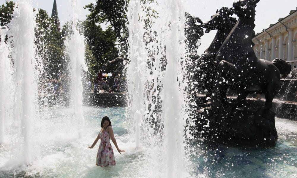 En la imagen de archivo, una joven moscovita se refresca en una fuente para combatir el calor cerca del Kremlin, en Moscú (Rusia). EFE/Yuri Kochetkov