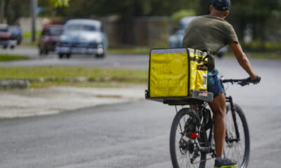Un mensajero de la empresa privada Mandao (de entrega de comida a domicilio) transita en bicicleta este domingo, por una de las calles de La Habana (Cuba). EFE/Yander Zamora