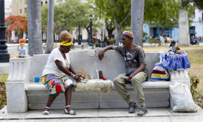 Un hombre se consulta con una mujer que lee las cartas, en el Parque de la Fraternidad en La Habana (Cuba). EFE/ Yander Zamora