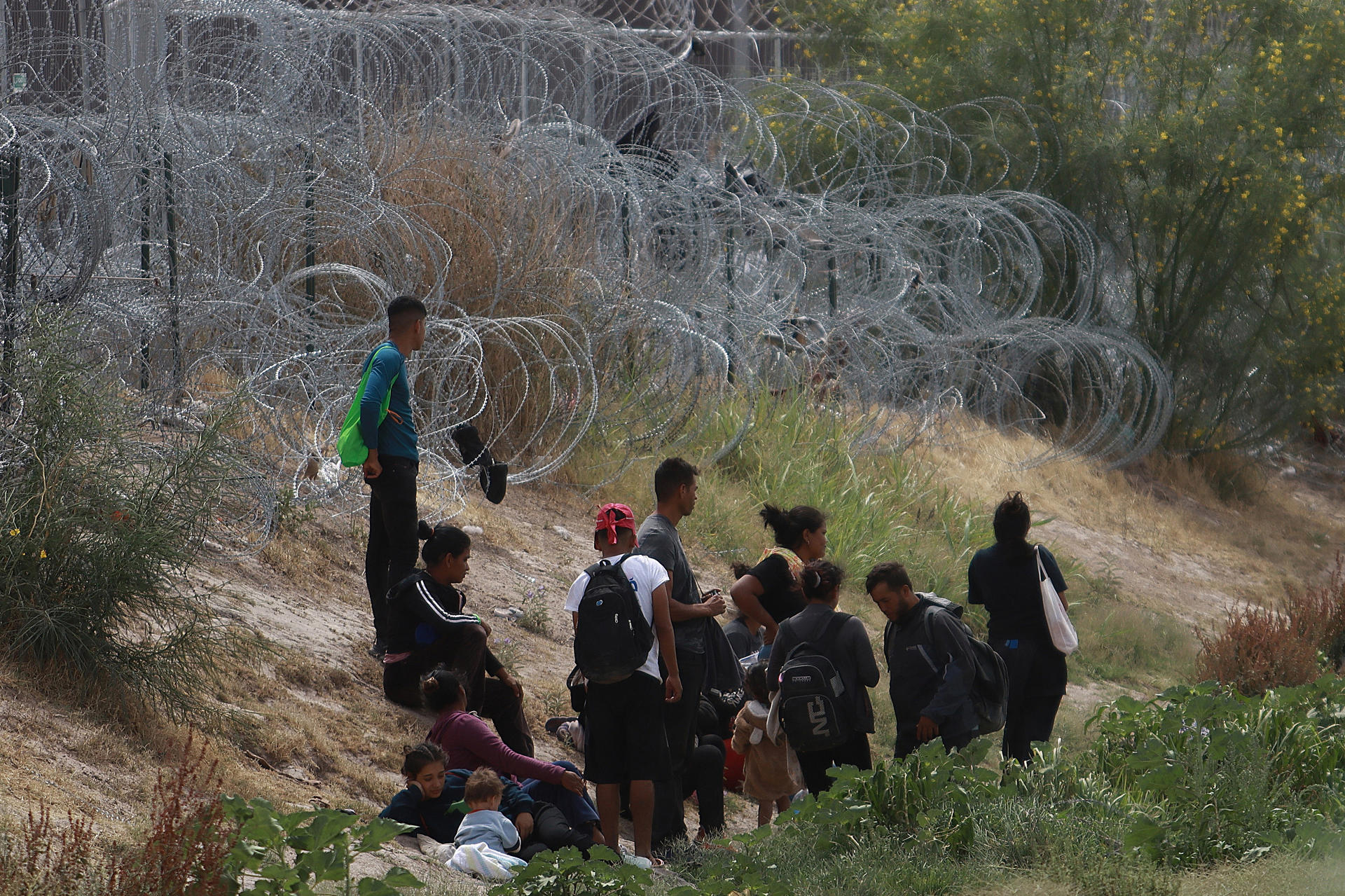 Migrantes permanecen cerca del muro que separa la frontera estadounidense, el 4 de junio de 2024, en Ciudad Juárez, Chihuahua (México). EFE/Luis Torres