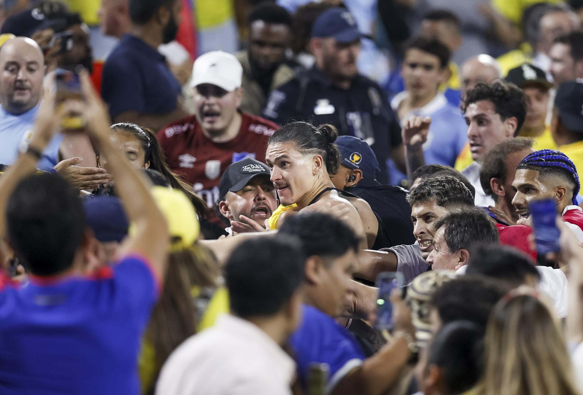 El delantero uruguayo Darwin Nuñez (c) fue registrado este miércoles, 10 de julio, al discutir con aficionados colombianos, al final de la segunda semifinal de la Copa América 2024, en las gradas del estadio Bank of America de Charlotte (Carolina del Norte). Colombia se impuso por 1-0 y accedió a la final. EFE/Brian Westerholt