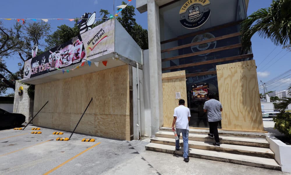 Trabajadores colocan tablas de madera para proteger un establecimiento por el paso del huracán Beryl, este miércoles en Cancún (México). EFE/Alonso Cupul