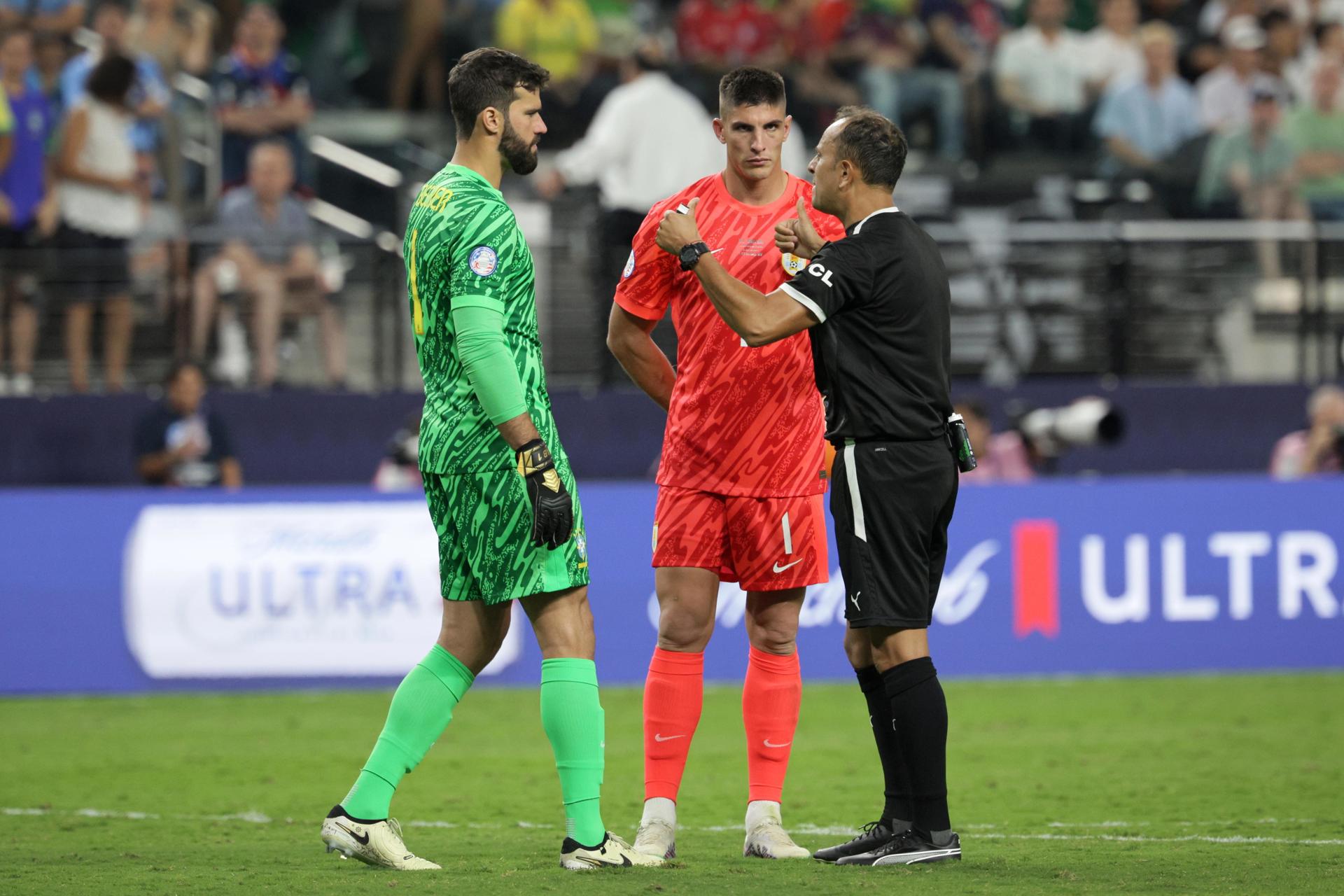 El árbitro Dario Humberto Herrera (d) habla con los porteros Alisson Becker de Brasil (i) y Sergio Rochet (C) de Uruguay en la Copa América 2024. EFE/EPA/ALLISON DINNER