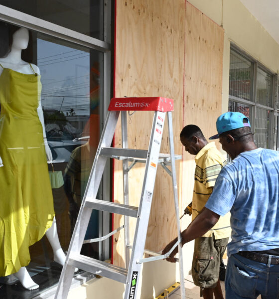 Personas cubren las fachadas de los negocios con tablones de madera ante la inminente llegada del huracán Beryl ayer martes en Kingston (Jamaica). EFE/ Rudolph Brown