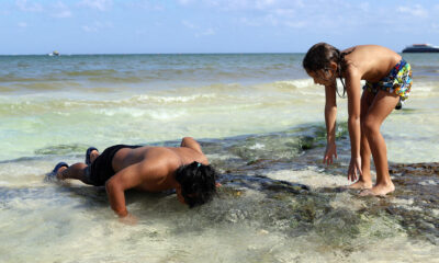 Turistas disfrutan de la formación de ojos de agua este martes, en Playa del Carmen, Quintana Roo (México). EFE/Lourdes Cruz