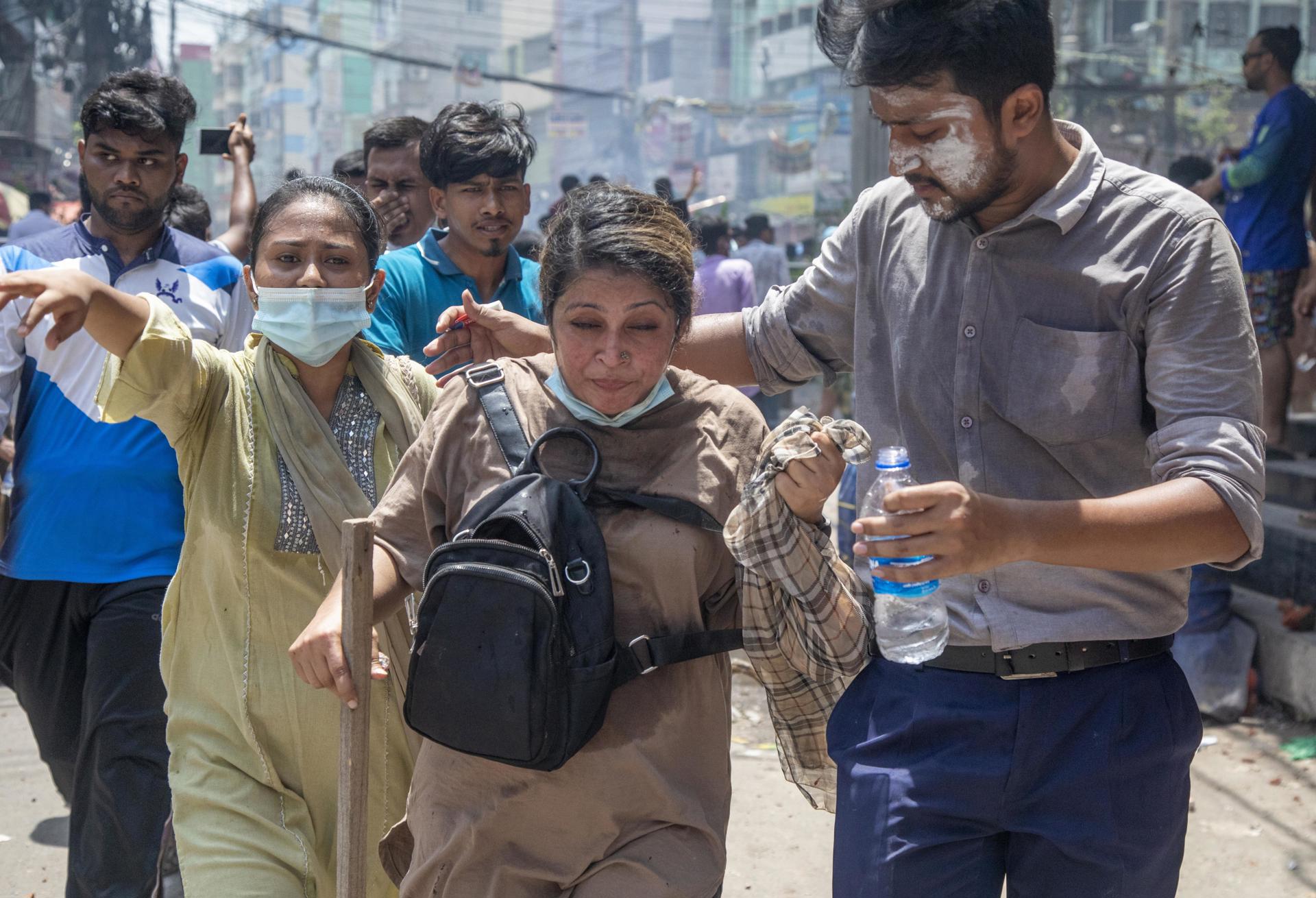Una persona herida recibe asistencia mientras los manifestantes se enfrentan a la policía durante las protestas de estudiantes en Daca, Bangladés, el 18 de julio de 2024. EFE/EPA/MONIRUL ALAM