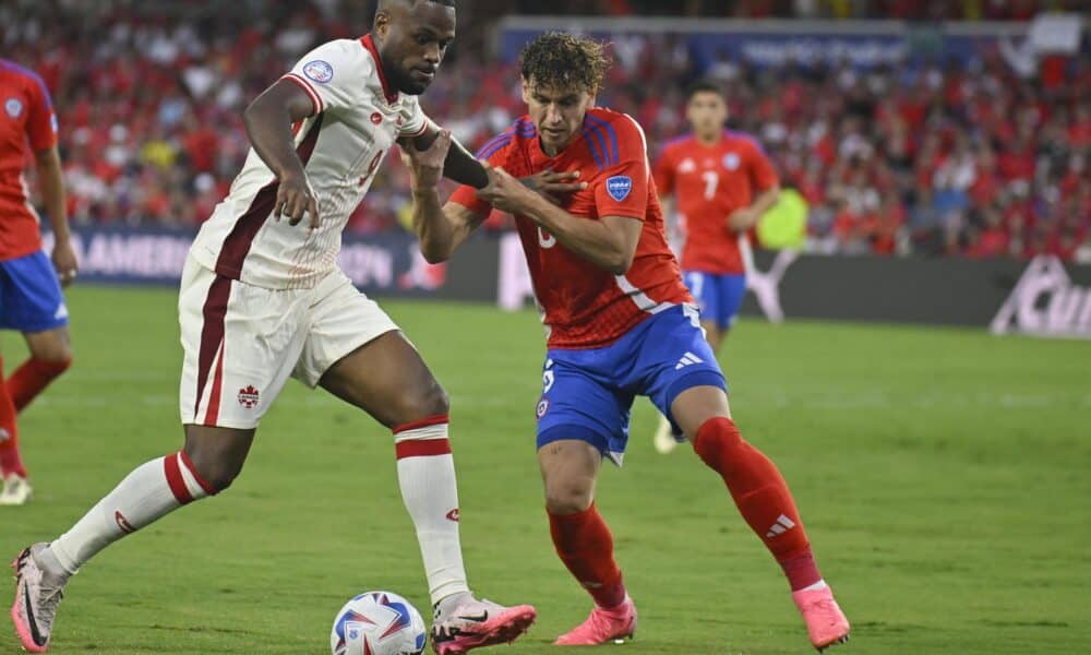 El delantero canadiense Cyle Larin (i) fue registrado este sábado, 29 de junio, al disputar un balón con el defensa chileno Igor Lichnovsky (c), durante el partido de cierre del grupo A de la Copa América 2024, en el estadio Inter&Co de Orlando (Florida, EE.UU.) EFE/Miguel Rodríguez