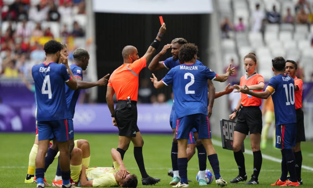 El árbitro Adel Al Naqbi (c) le saca la tarjeta roja al dominicano Edison Azcona (d) tras una acción contra Pau Cubarsí (en el suelo) durante el partido del Grupo C de fútbol masculino de los Juegos Olímpicos de París 2024 disputado este sábado en el Estadio de Burdeos. EFE/ M. Reino