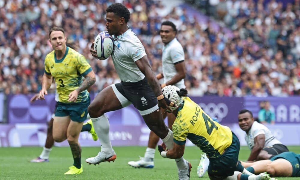 El jugador Jerry Tuwai, de Fiji, deja a trás al australiano durante el partido de semifinales que han jugado Fiji y Australia en el Stade de France en Saint Denis, Francia. EFE/EPA/CHRISTOPHE PETIT TESSON