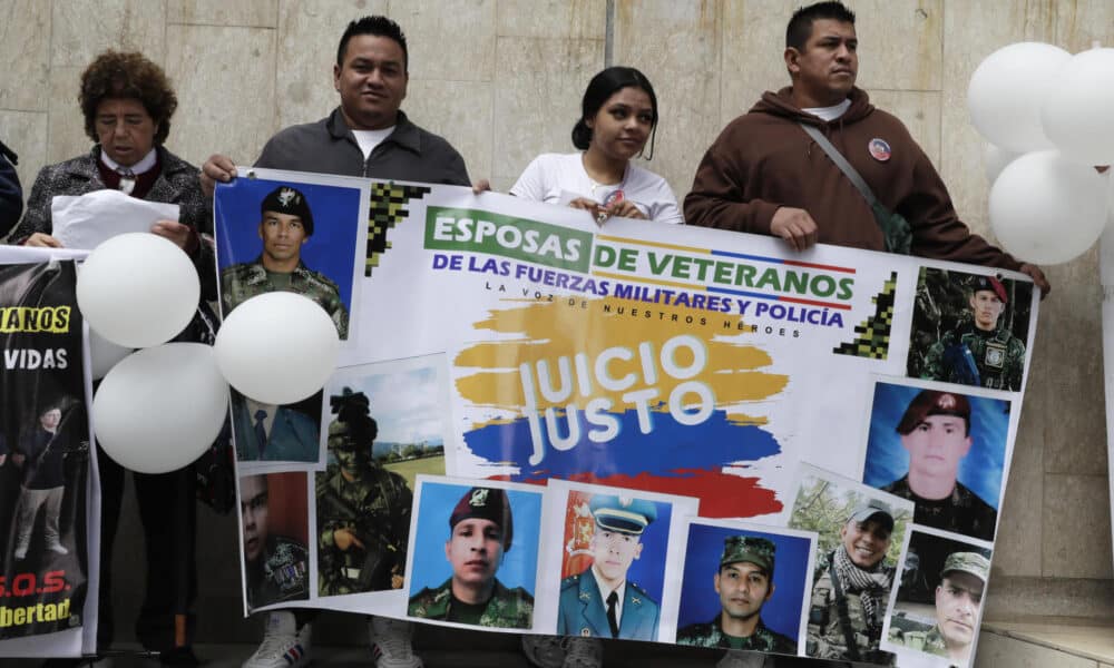 Familiares de los 17 exmilitares detenidos en Haití sostienen pancartas durante una protesta, este jueves, en Bogotá (Colombia). EFE/ Carlos Ortega