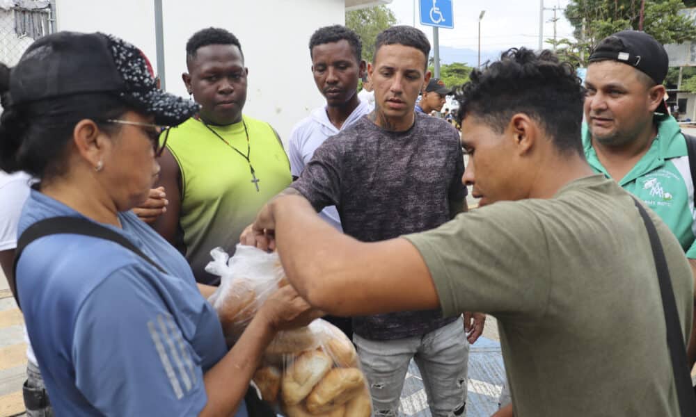 Migrantes reciben comida este viernes de parte de un integrante de una asociación civil en la ciudad de Escuintla, en el estado de Chiapas (México). EFE/Juan Manuel Blanco