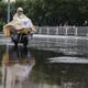 Una mujer anda en scooter durante una fuerte lluvia, en una calle de Beijing (China), el 30 de julio de 2024. El Observatorio Meteorológico Central siguió emitiendo una alerta naranja por tormenta para el martes. EFE/EPA/Wu Hao