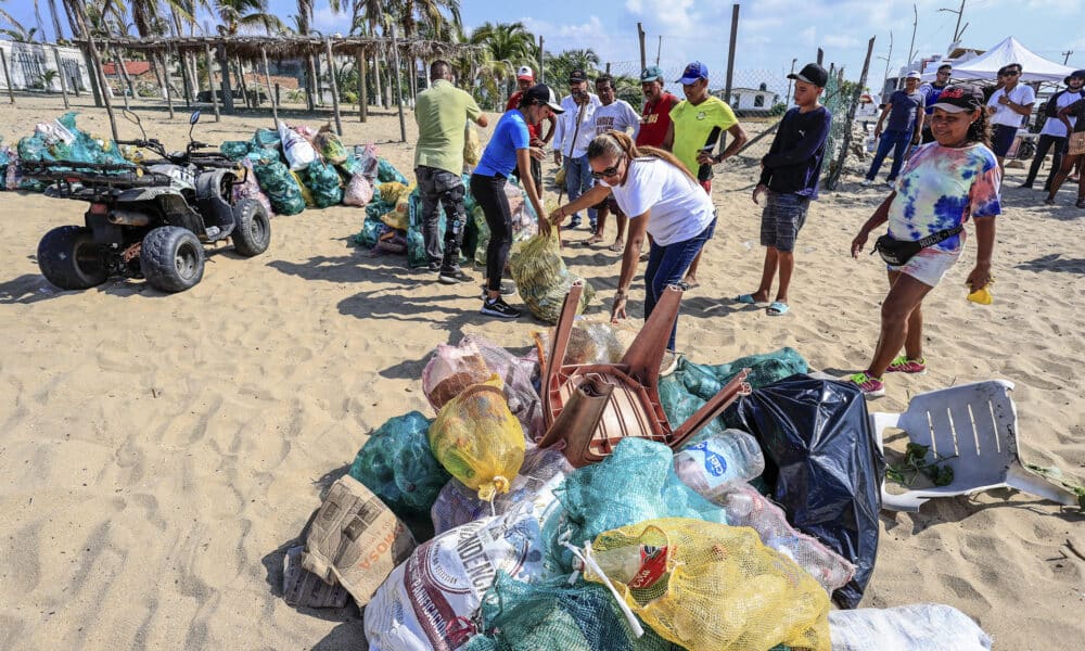 Voluntarios recogen basura de la arena de la playa de Pie de la Cuesta, este lunes en Acapulco (México). EFE/David Guzmán