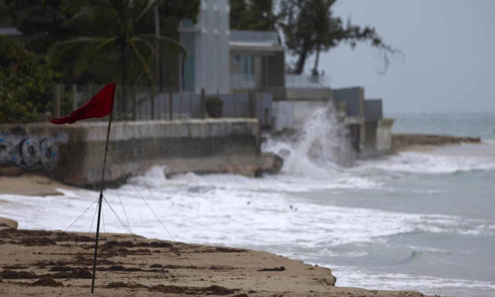 Una bandera muestra los fuertes vientos en la Playa de Ocean Park, este martes 13 de agosto de 2024 en San Juan (Puerto Rico), provocados por la tormenta tropical Ernesto. EFE/ Thais Llorca