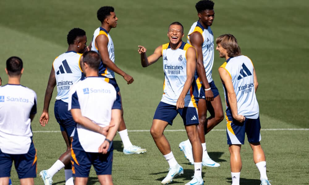 El delantero del Real Madrid Kylian Mbappé (3d) bromea con sus compañeros durante el entrenamiento de esta mañana en la Ciudad Deportiva de Valdebebas para preparar el primer partido de Liga mañana frente al Mallorca. EFE/Daniel González