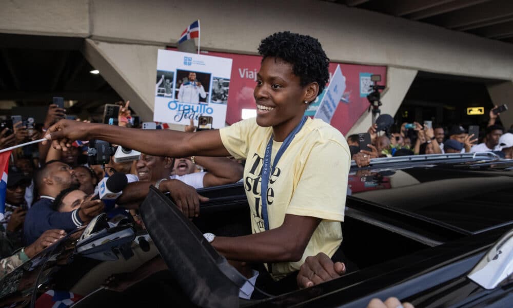 Marileidy Paulino, ganadora de la medalla de oro en los 400 metros en los Juegos Olímpicos de París 2024, saluda durante su recibimiento en el Aeropuerto Internacional de las Américas, en Santo Domingo (República Dominicana). EFE/Orlando Barría