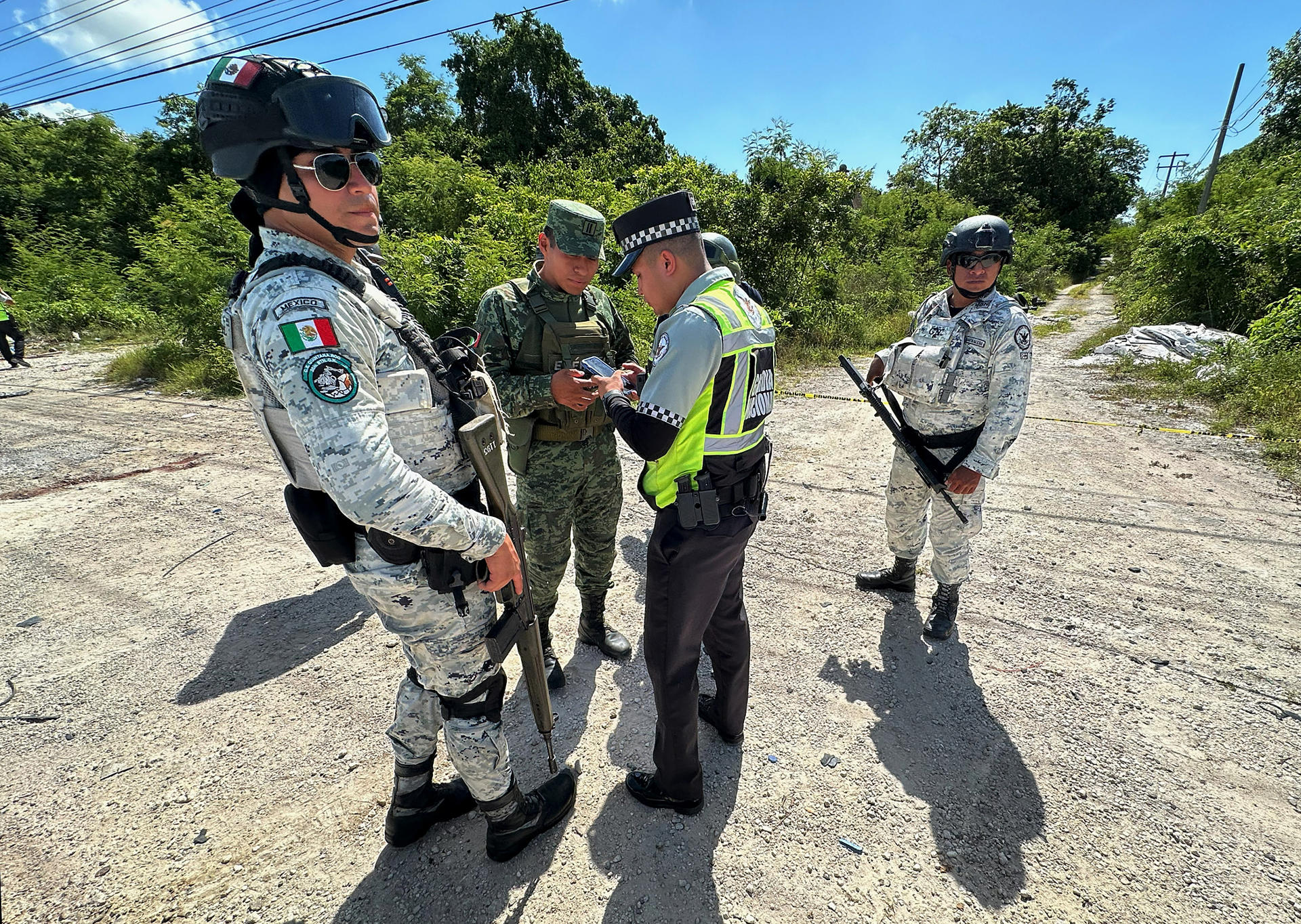 Integrantes de la Guardia Nacional (GN) y del ejército mexicano resguardan la zona donde se localizaron los cuerpos de 4 personas, en el balneario de Cancún (México). EFE/ Alonso Cupul