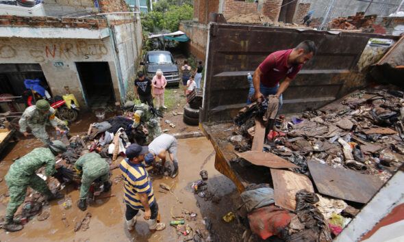 Habitantes de las colonias afectadas por las fuertes lluvias de la madrugada de éste miércoles, retiran lodo y escombros en la ciudad de Zapotlanejo, Jalisco (México). EFE/Francisco Guasco