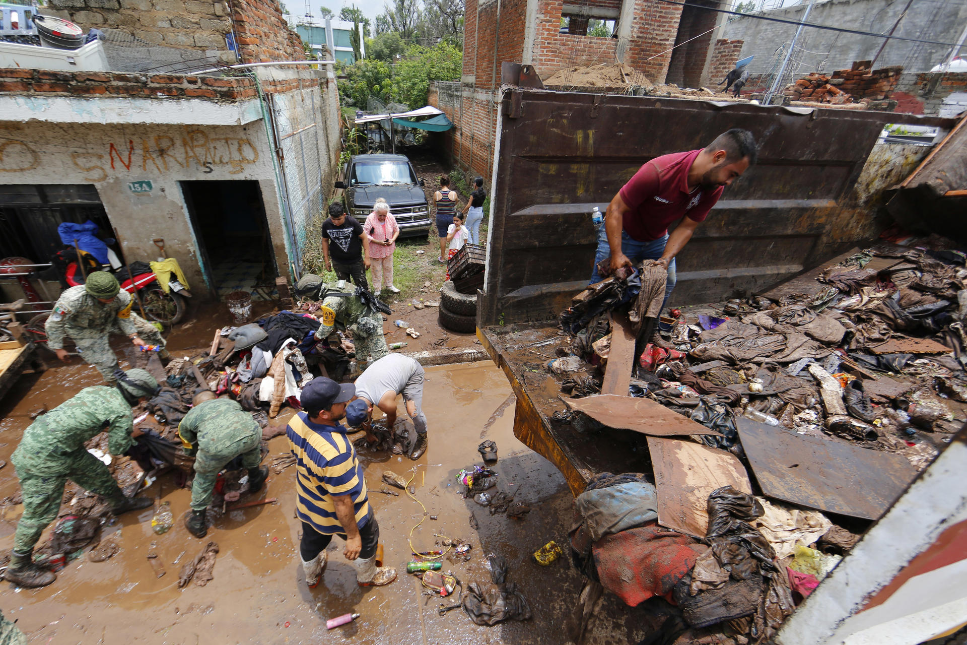 Habitantes de las colonias afectadas por las fuertes lluvias de la madrugada de éste miércoles, retiran lodo y escombros en la ciudad de Zapotlanejo, Jalisco (México). EFE/Francisco Guasco