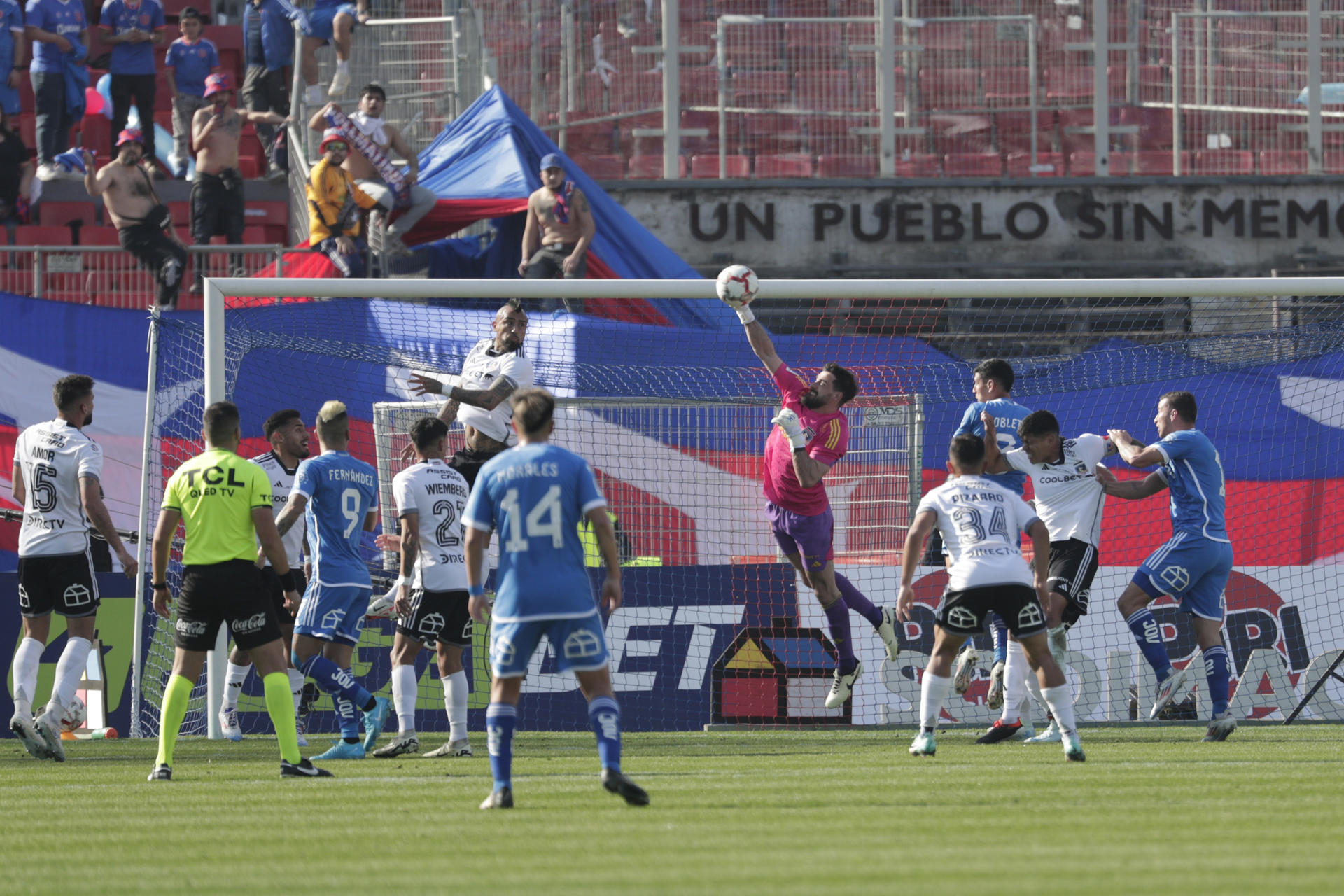 Fernando de Paul (c-d), guardameta de la Universidad de Chile, fue registrado este sábado, 10 de agosto, al atajar un balón disparado por jugadores de Colo Colo, durante un partido del Campeonato Nacional chileno de fútbol, en el Estadio Nacional de Santiago de Chile. EFE/Elvis González