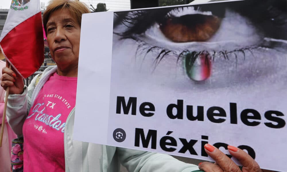 Una mujer sostiene un cartel durante una protesta frente a las instalaciones del Instituto Nacional Electoral (INE) este domingo en Ciudad de México (México). EFE/ Mario Guzmán