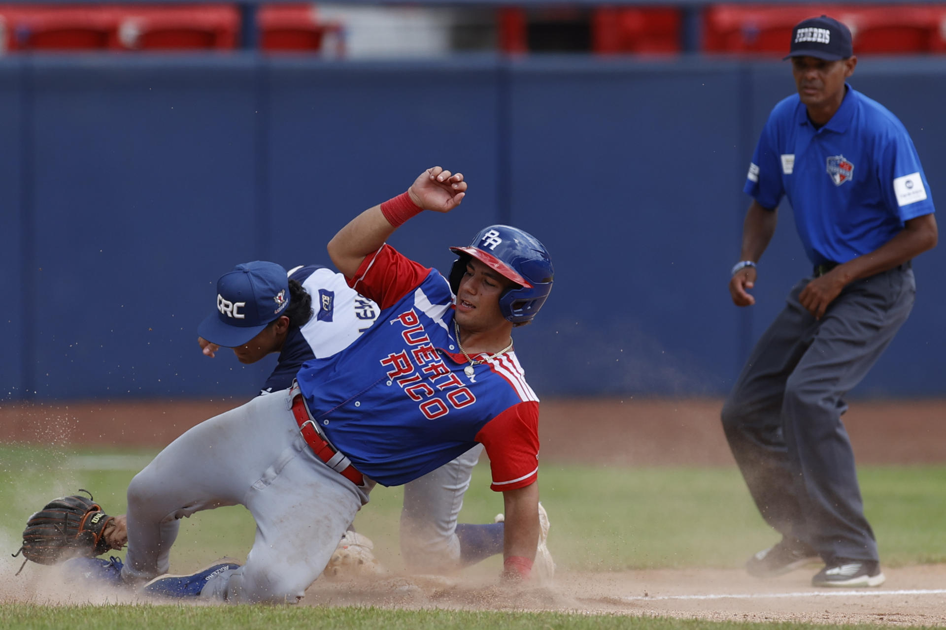 Everth Bermúdez (i), de Costa Rica, fue registrado este miércoles, 7 de agosto, al atrapar en tercera base a Xavier Rivera (d), de Puerto Rico, durante un partido del Premundial U18 de béisbol, en Ciudad de Panamá (Panamá). EFE/Bienvenido Velasco