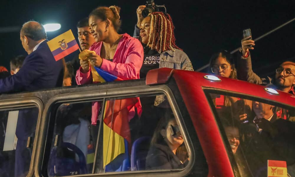 Las hermanas ecuatorianas y medallistas olímpicas, Neisi Dajomes (d) bronce en pesas en -76 kilos, y Angie Palacios (i) bronce en la categoría de -71 kilos, saludan a su llegada este lunes a Quito. EFE/José Jácome