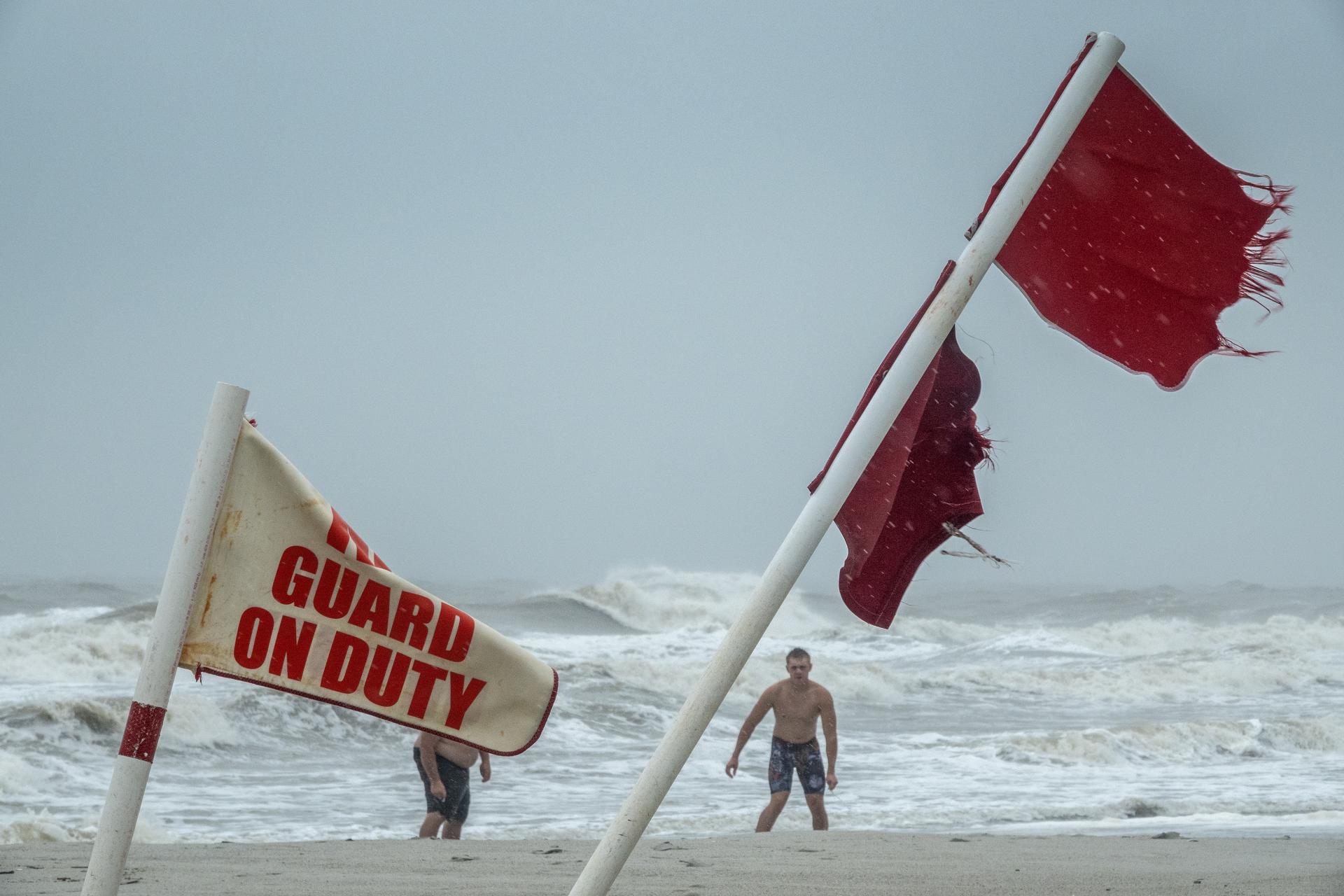 Banderas rojas mientras la gente camina por la playa durante la lluvia que genera la tormenta tropical Debby en Myrtle Beach, Carolina del Sur, Estados Unidos, el 7 de agosto de 2024. EFE/CRISTÓBAL HERRERA-ULASHKEVICH