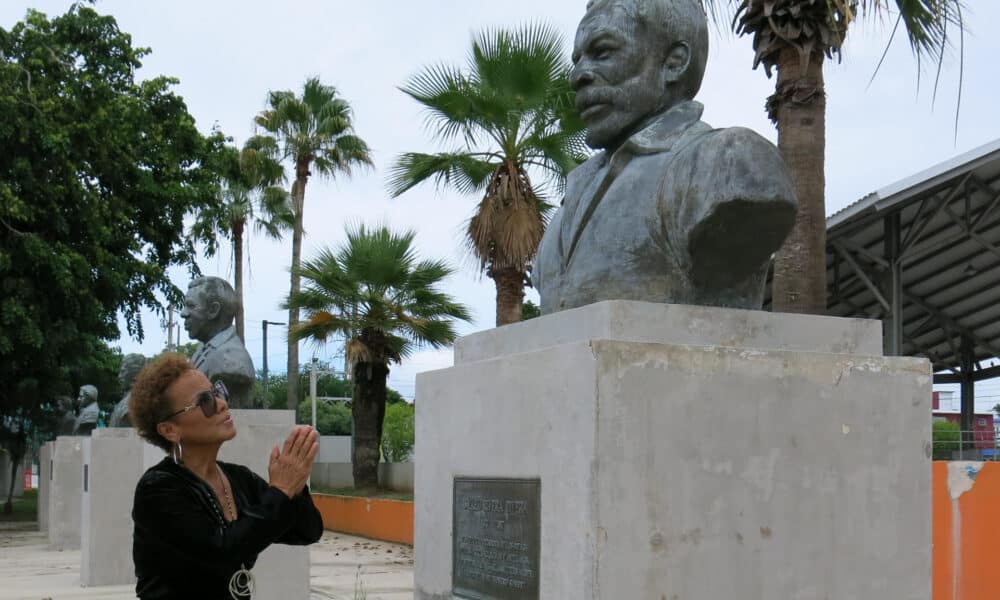 La salsera Choco Orta posa junto a un busto del cantante Ismael Rivera el 10 de julio de 2024, en la Plaza de los Salseros en San Juan (Puerto Rico). EFE/ Jorge Muñiz