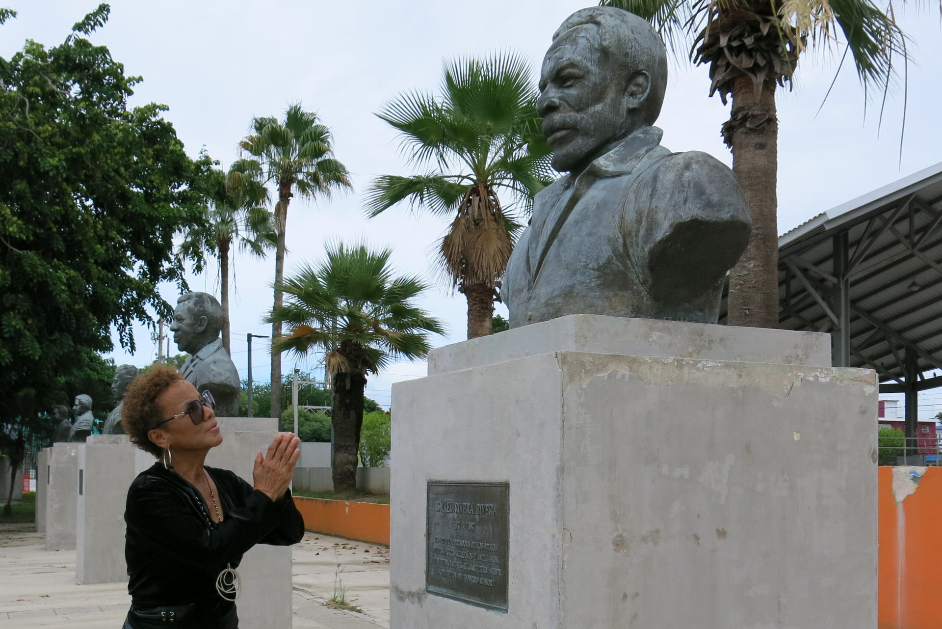 La salsera Choco Orta posa junto a un busto del cantante Ismael Rivera el 10 de julio de 2024, en la Plaza de los Salseros en San Juan (Puerto Rico). EFE/ Jorge Muñiz