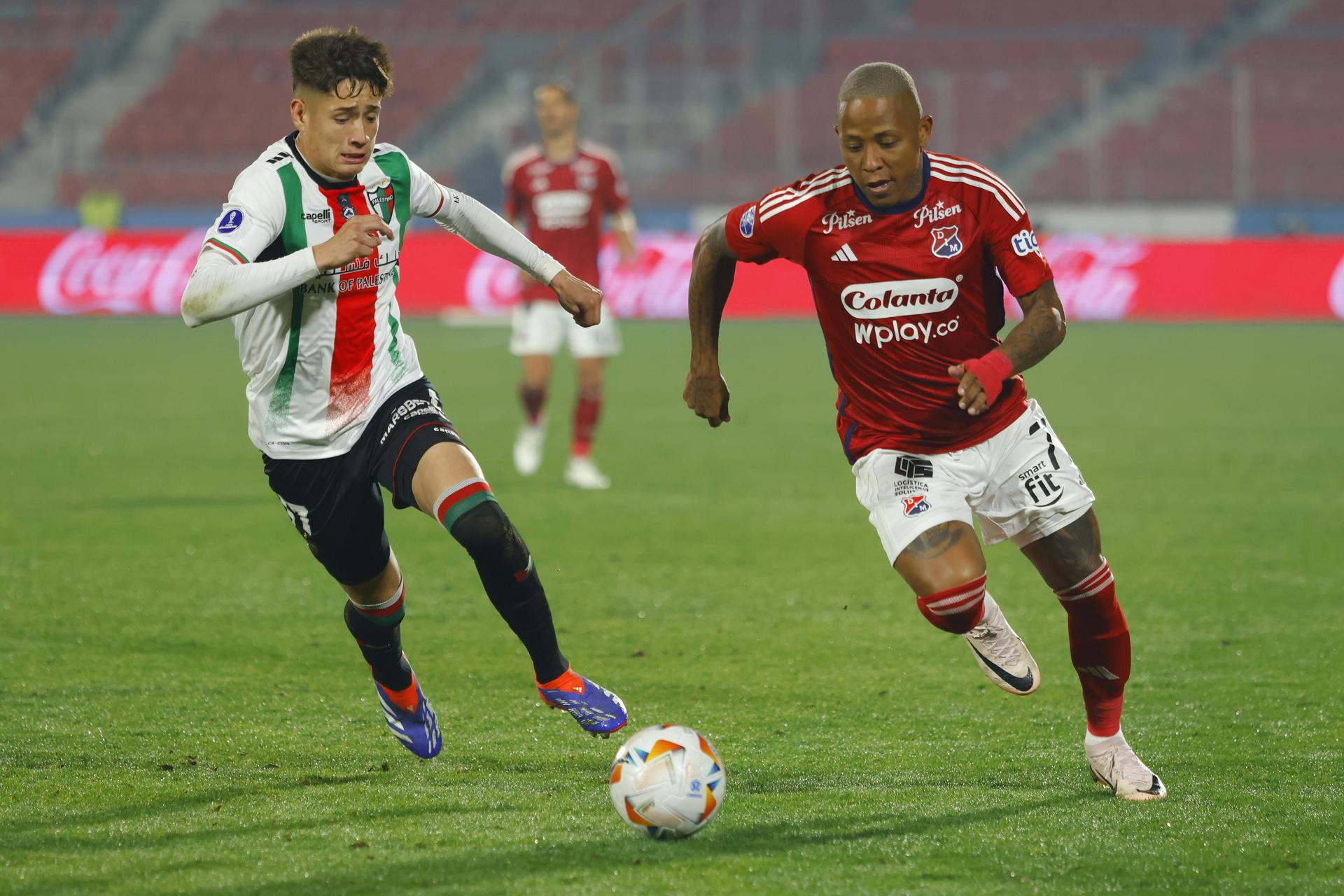 Iván Román (i) de Palestino disputa el balón con Jhon Vásquez (d) de Medellín en el partido de ida de octavos de final de la Copa Sudamericana. EFE/ Esteban Garay